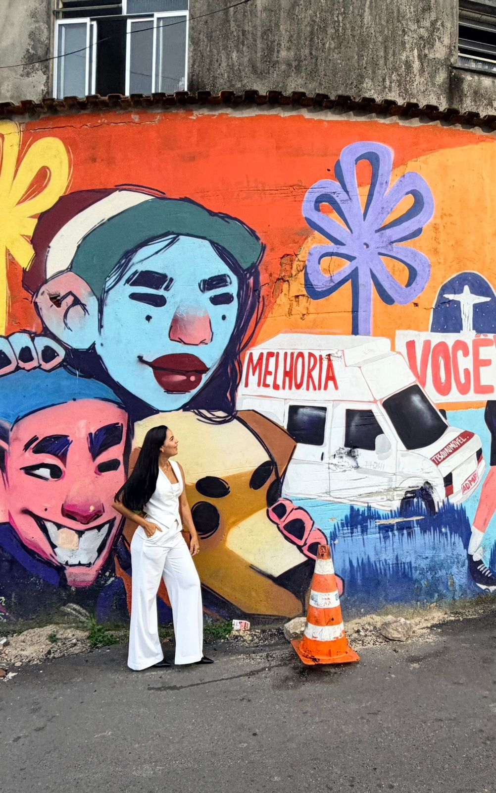Moradora em frente a mural colorido na comunidade